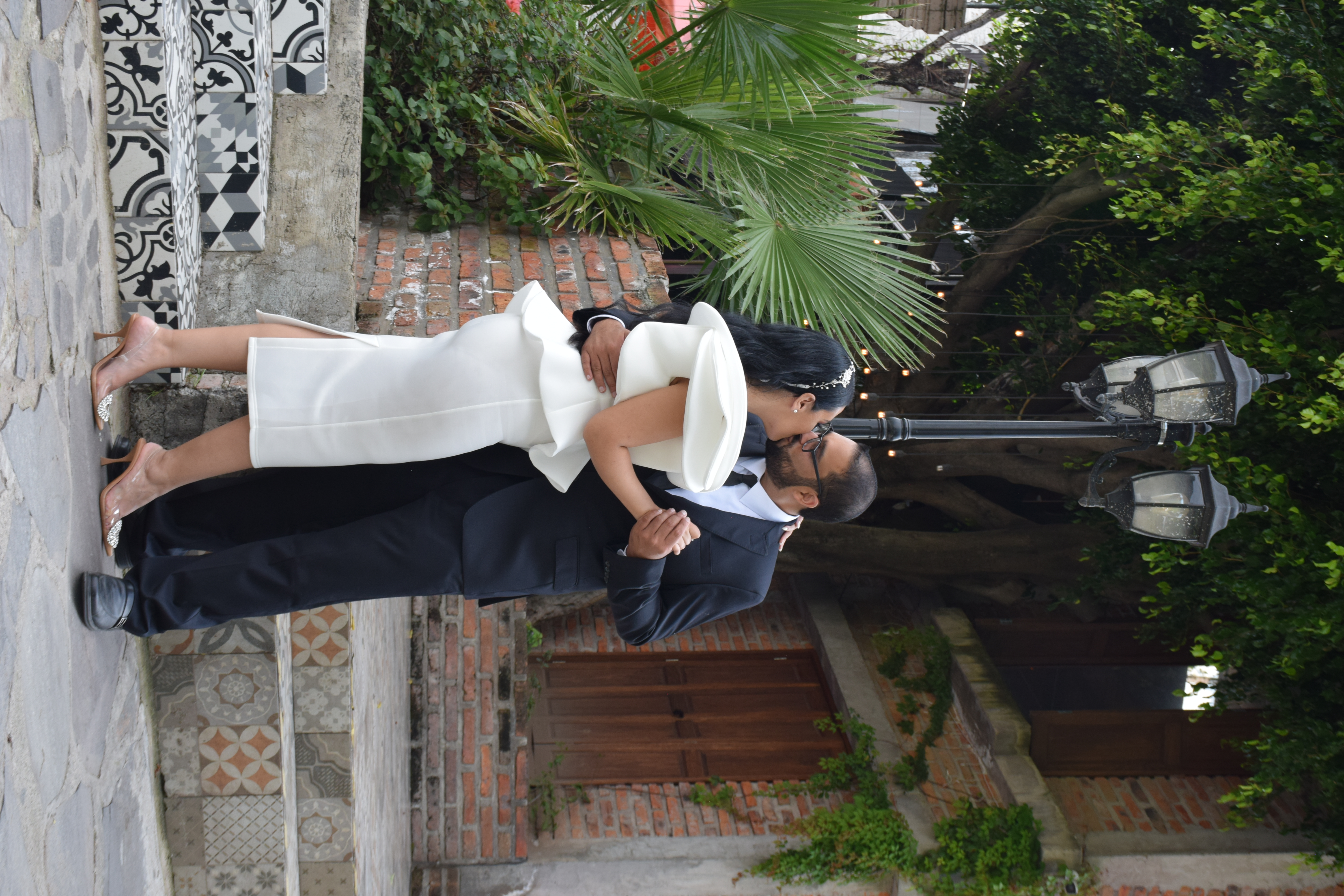 Pareja de recién casados bailando en un patio histórico
